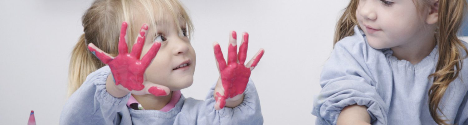 Girls finger-painting in classroom